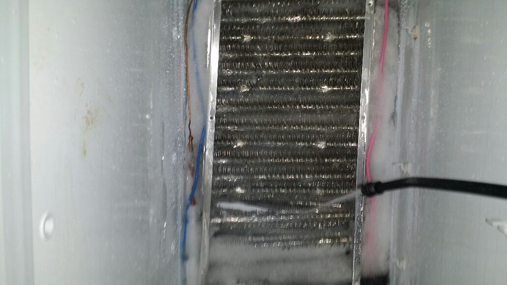Using a sprayer on the evaporator coils. - Click to Zoom Using a sprayer on the evaporator coils.